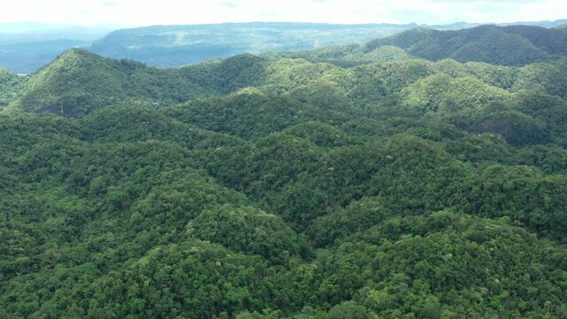 Drone panning over jungle on island in Philippines with island in distance Philippines