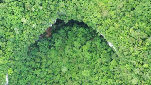 Drone flying over cave opening overgrown with forest in Samar Philippines