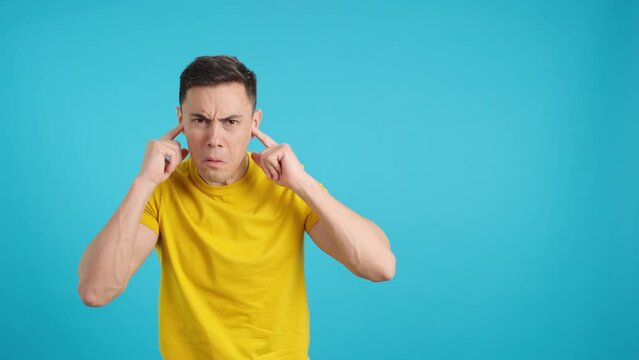 Man covers his ears with his hands due to noise