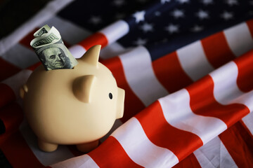 Closeup view of an American flag with a pink piggy bank for various financial concepts.