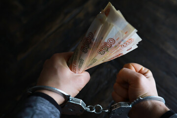 Handcuffs behind, five thousand rubles. Concept of corruption