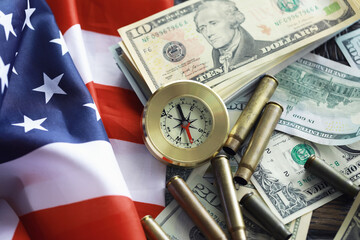 Money bill with golden Compass. Bullets and cartridge cases as a military concept. Close up US...