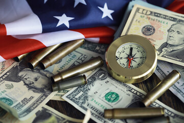 Money bill with golden Compass. Bullets and cartridge cases as a military concept. Close up US Currency and compass. business, financial idea, concept, symbol of crisis, inflation
