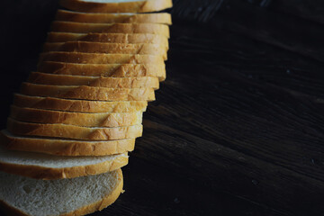 long loaf on a wooden board and knife isolated on a white background. Tasty bread