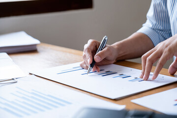 Businesswoman working on laptop analyzing charts and graphs.