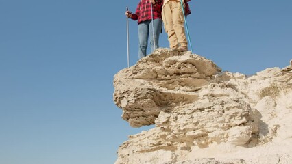 Two women hikers standing on edge of cliff top. Active lifestyle of middle-aged people in travel.