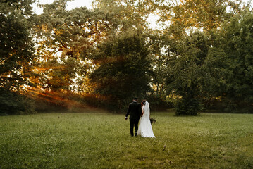 bride and groom walking in the park