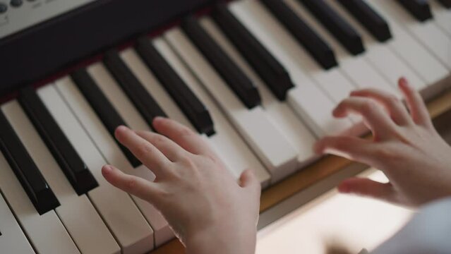 Kid musician performs composition on piano with inspiration