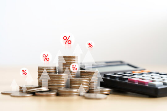 the calculator and coins money with up arrow and percentage symbol for financial banking increase interest rate or investment dividends. tax, vat concept, and Rise interest rates.