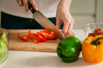 A girl prepares a salad of fresh vegetables