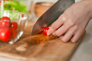 A girl prepares a salad of fresh vegetables