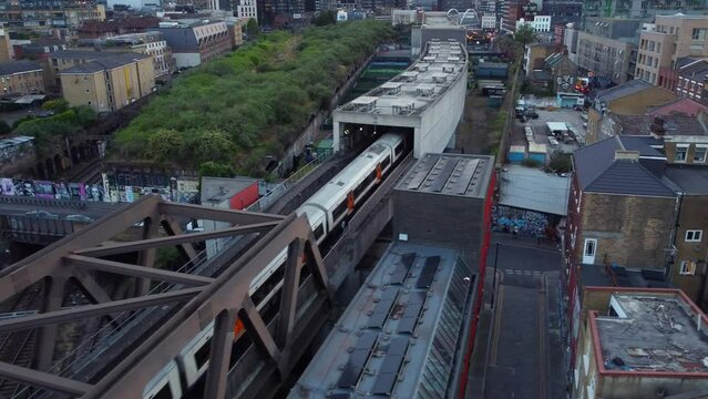 Drone shot London overground tube travelling through commuter town