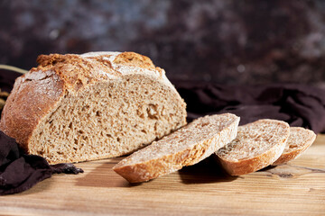 Golden bread next to ears of wheat on a table