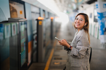 Asian woman stands in railcar waiting for an railcar in the subway. young women holding telaphone....