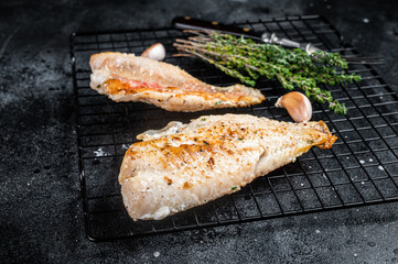 Grilled sea red perch fillet, Snapper fish on a rack. Black background. Top view