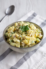 Homemade Potato Egg Salad with Pickles in a Bowl, side view.