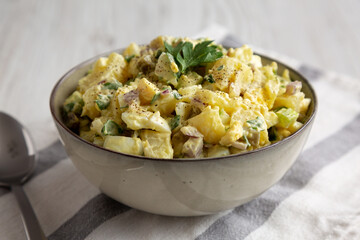 Homemade Potato Egg Salad with Pickles in a Bowl, side view.