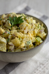 Homemade Potato Egg Salad with Pickles in a Bowl, side view.