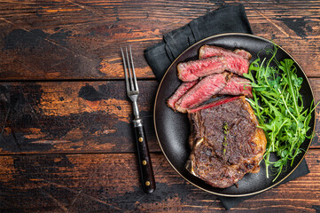 BBQ Grilled Wagyu New York beef meat steak or Striploin steak in a plate with salad. Wooden...