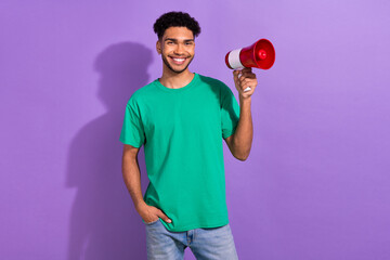 Photo of cheerful cool guy dressed green t-shirt holding loud speaker empty space isolated violet...