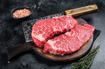 Fototapeta na wymiar Marbled beef Denver raw meat steak with herbs. Black background. Top view