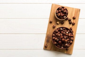 Wooden bowl full of hazelnuts on table background. Healthy eating concept. Super foods