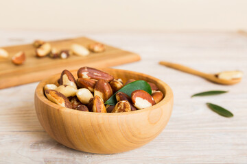 Fresh healthy Brazil nuts in bowl on colored table background. Top view Healthy eating bertholletia concept. Super foods