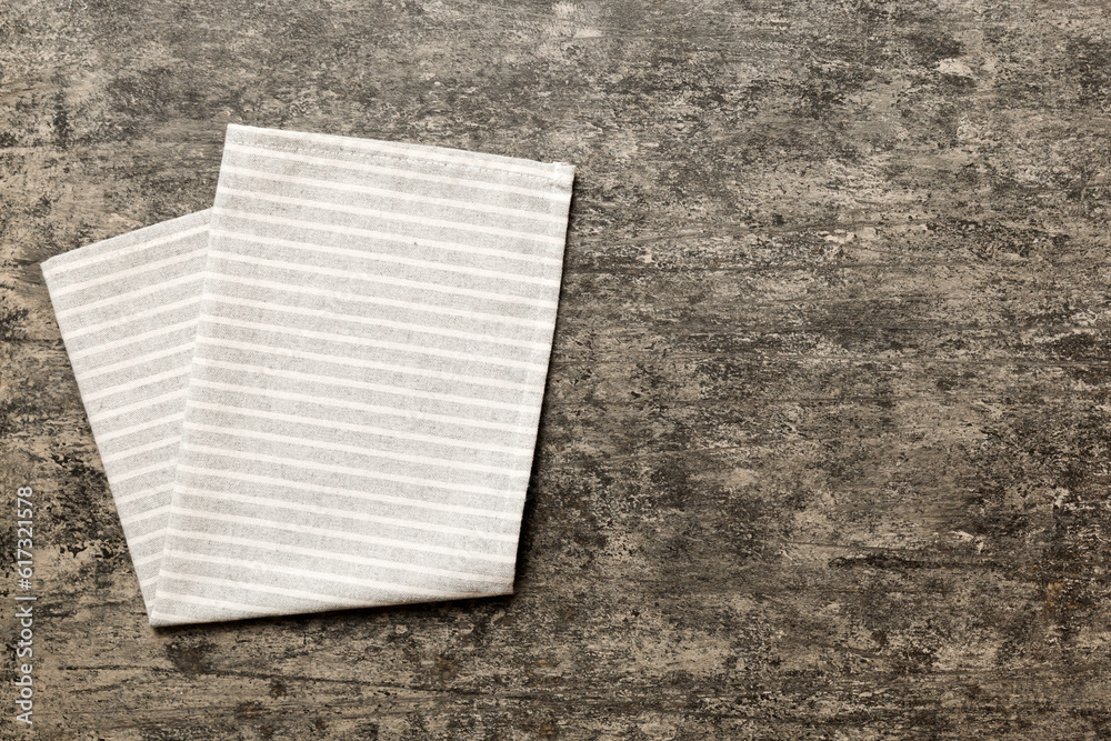 Wall mural top view with gray kitchen napkin isolated on table background. Folded cloth for mockup with copy space, Flat lay. Minimal style