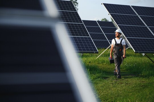 a worker walks through a solar panel farm