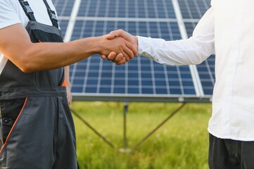 Shaking hands of businessmen and engineers after the conclusion of the agreement in the renewable energy and green energy concept industry to replace the traditional production of electricity.