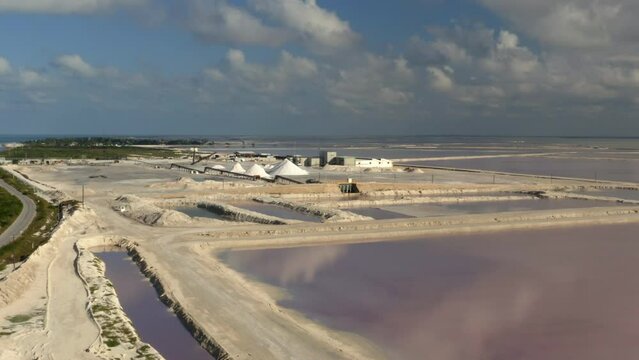 Pink salt evaporation ponds and salt mounds in sea saltern in Mexico.