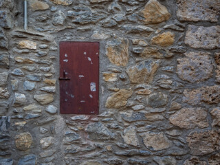 imagen detalle pared de piedras de distintos tamaños, con las juntas de cemento, y una puerta...