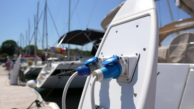 Electrical power outlet on a ship harbour bay. 4k wide angle video with the electricity outlets used for parked ships and yachts at the sea side marina. Romania, 2023.