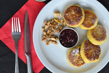 a plate with cheesecakes on a black table
