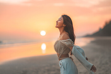 Side view of young asian woman with freedom on the sea beach at golden sunset, Female tourist on seaside summer vacation, Go Everywhere.