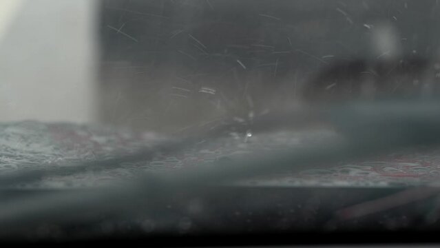 Summer rain on the road. Close up 4K video with water bouncing from the hood while stuck in traffic.