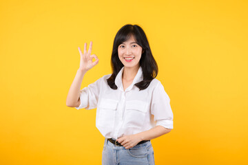 Young businesswoman hand sign okay gesture. Asian woman happy smile wearing white shirt and jean...