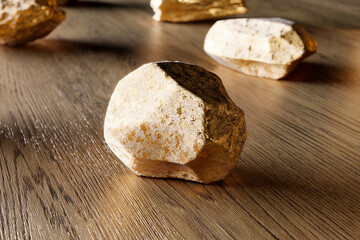 A group of pure gold pieces on the wooden background. Golden nuggets. Gold ore