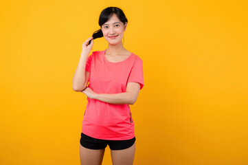 Portrait beautiful young asian sports fitness woman happy smile wearing pink sportswear posing exercise training workout isolated on yellow studio background. wellbeing and healthy lifestyle concept.