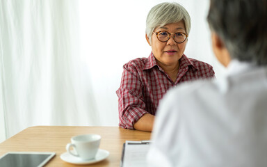 Asian senior doctor wearing uniform with stethoscope help discussing and consulting talk to sick senior patient checkup information, support, care, diseases, treatment in hospital.elderly healthcare