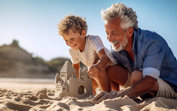 A grandfather with his little grandson builds a sand castle on the beach. Happy and joyful