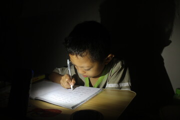 The boy studied accompanied by a candle