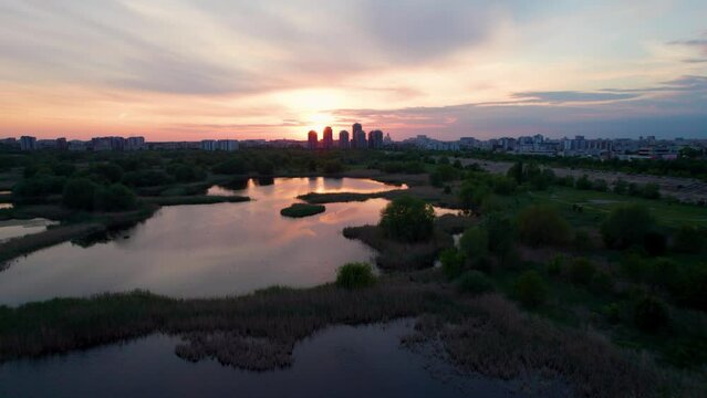 Aerial View Over Vacaresti Delta At Sunset With Birds Flying, Cityscape In The Background, Sunset Colors, Orange, Red, Yellow, Bucharest, Romania