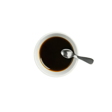 The image is an up-close shot of a cup of espresso coffee, placed on a table. The coffee cup features a spoon, which is resting inside the cup. 