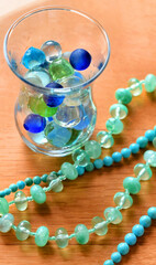 夏のインテリア雑貨、テーブルに置いたビー玉とネックレス