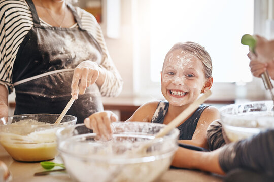 Portrait, Playing Or Messy Kid Baking In Kitchen With A Young Girl Smiling With Flour On A Dirty Face At Home. Smile, Happy Or Parent Cooking Or Teaching A Fun Daughter To Bake For Child Development