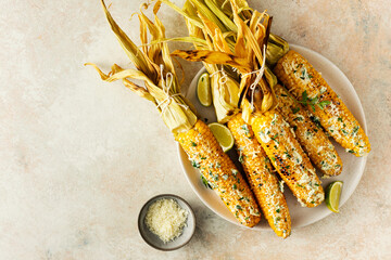 Grilled corn cobs with butter, cheese and herbs,