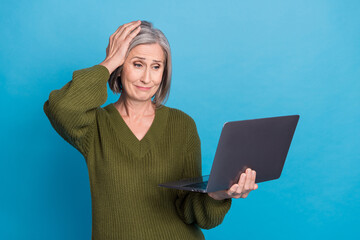 Portrait of unhappy dissatisfied woman wear khaki sweater look at laptop hand on head got critical...
