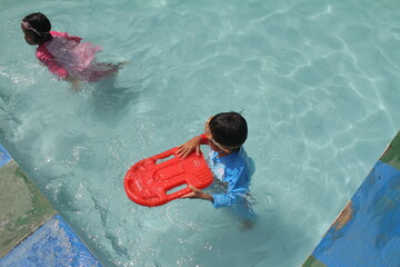 boys and girls practice swimming and playing in water
