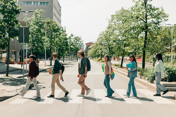 students in single file cross the street on pedestrian crossings as in abbey road